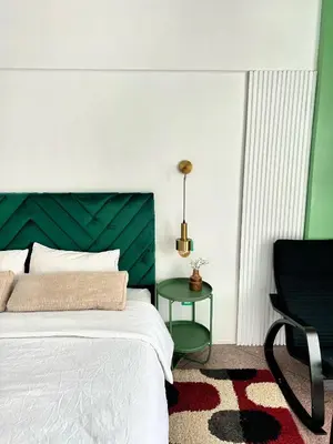 a bedroom with a bed with a green headboard and a chair at Cosy vintage appartement with terrace in Rabat