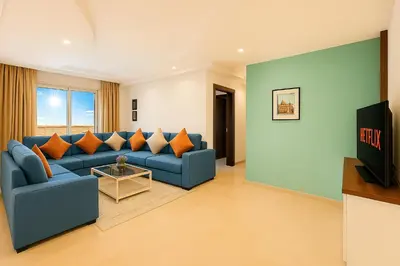 a living room with a blue couch and orange pillows at Cosy sunny 2BR - central near train and tram in Casablanca