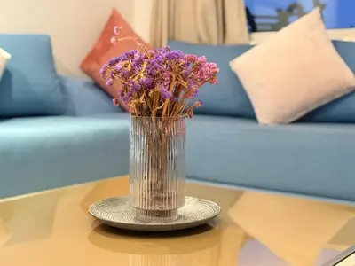 a vase filled with purple flowers on a table at Cosy sunny 2BR - central near train and tram in Casablanca