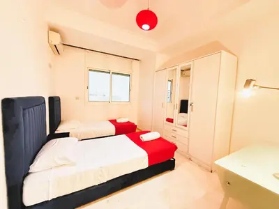 a small bedroom with two beds and a bathroom at Cosy sunny 2BR - central near train and tram in Casablanca