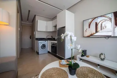 a kitchen with white cabinets and a table at Studio au coeur de Casablanca in Casablanca