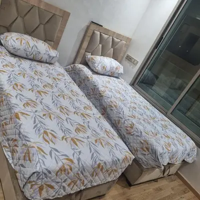 a bedroom with a bed with a comforter and pillows at appartement haut standing avec piscine a cote de la plage et du golf a bouznika in Bouznika
