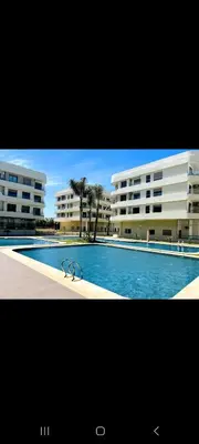 a large swimming pool in front of two buildings at appartement haut standing avec piscine a cote de la plage et du golf a bouznika in Bouznika