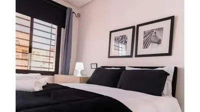 a bedroom with a black and white bed and a window at studio ensoleillé à Rabat in Rabat