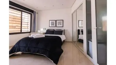 a bedroom with a large bed and a window at studio ensoleillé à Rabat in Rabat