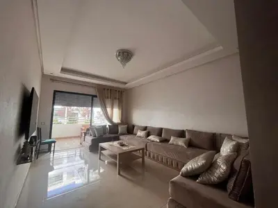 a living room with a couch and a table at Salah in Bouznika