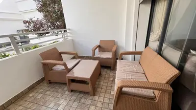 a balcony with wicker chairs and a table and chairs at Salah in Bouznika