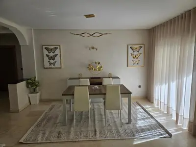 a dining room with a table and chairs at Superbe appartement meublé, lumineux et idéalement situé in Casablanca