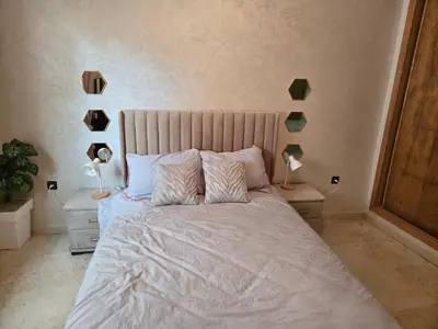 a bedroom with a large bed with two pillows at Superbe appartement meublé, lumineux et idéalement situé in Casablanca