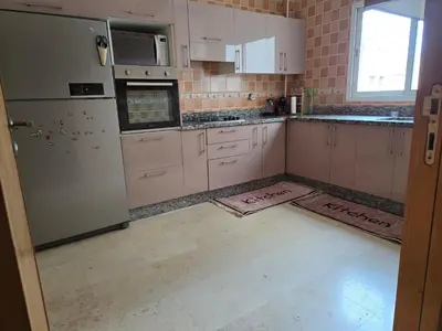 a kitchen with white cabinets and a refrigerator at Superbe appartement meublé, lumineux et idéalement situé in Casablanca