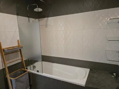 a bathroom with a tub and a glass shower door at Superbe appartement meublé, lumineux et idéalement situé in Casablanca