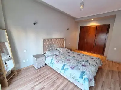a bedroom with a bed and a wooden floor at Elegant 2-Bedroom Apartment in Vibrant Maarif in Casablanca