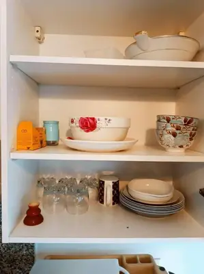 a shelf with plates and bowls and other dishes at Elegant 2-Bedroom Apartment in Vibrant Maarif in Casablanca
