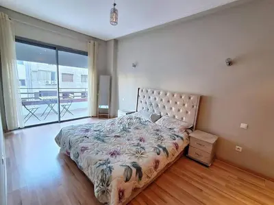 a bedroom with a large bed and a balcony at Elegant 2-Bedroom Apartment in Vibrant Maarif in Casablanca