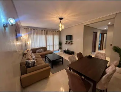 a living room with a couch and a table with chairs at Elegant 2-Bedroom Apartment in Vibrant Maarif in Casablanca