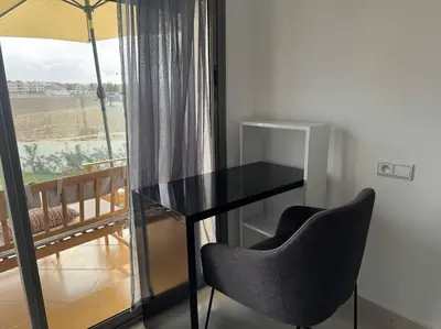 a black table and chairs in a room with a window at Luxueux Appartement avec Piscine et Terrasse in Bouznika