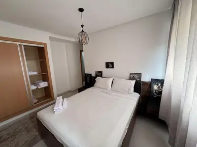 a bedroom with a large bed and a window at Luxueux Appartement avec Piscine et Terrasse in Bouznika