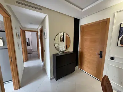 a hallway with a mirror on top of a dresser at Luxueux Appartement avec Piscine et Terrasse in Bouznika