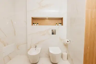 a white bathroom with a toilet and a sink at Perla in Rabat