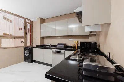 a kitchen with white cabinets and a black counter top at Perla in Rabat