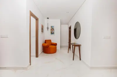 a hallway with an orange chair and a table at Perla in Rabat