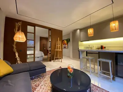 a living room with a couch and a table at Findy Maarif avec jardin privé in Maarif