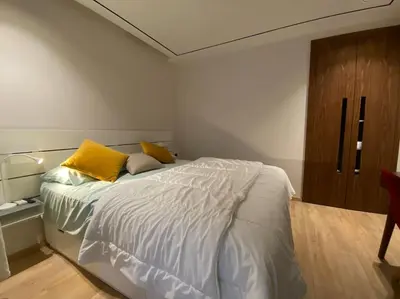 a bedroom with a large bed with yellow pillows at Findy Maarif avec jardin privé in Maarif