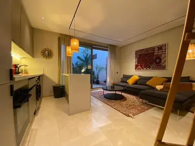 a living room with a couch and a table at Findy Maarif avec jardin privé in Maarif