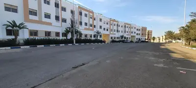 an empty street in front of a large building at Settat room Homy in Settat
