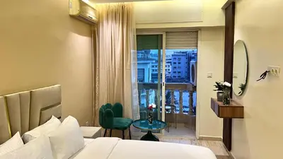 a hotel room with a bed and a table and a window at Stylish 2BR Appartement Central - 5 min Casa port in Casablanca