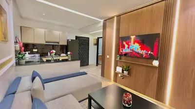 a living room with a couch and a kitchen at Stylish 2BR Appartement Central - 5 min Casa port in Casablanca