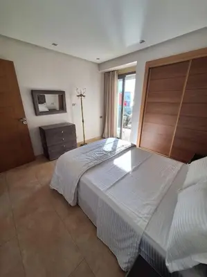 a bedroom with a large bed and a window at Appartement piscine front de mer in Mohammedia