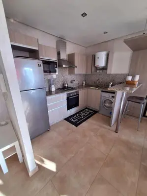 a kitchen with a stainless steel refrigerator and a dishwasher at Appartement piscine front de mer in Mohammedia