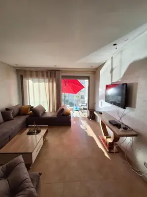 a living room with a couch and a tv at Appartement piscine front de mer in Mohammedia
