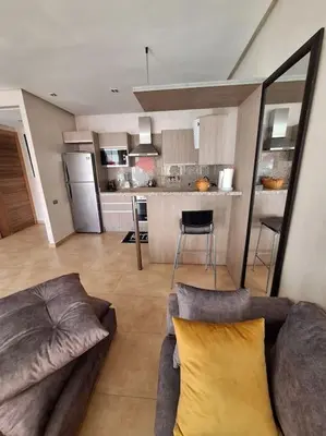 a living room with a couch and a kitchen at Appartement piscine front de mer in Mohammedia