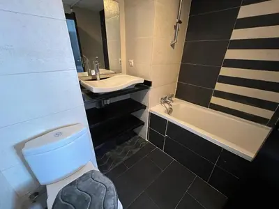a bathroom with a toilet and a sink and a tub at Appartement Cosy Vue sur Mer in Dar Bouazza
