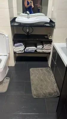 a bathroom with a sink and a counter with towels at Appartement Cosy Vue sur Mer in Dar Bouazza