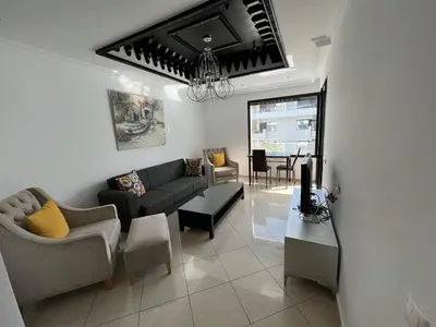 a living room with a couch and a table at Appartement Cosy Vue sur Mer in Dar Bouazza