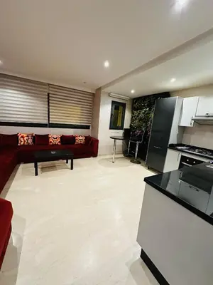 a living room with a red couch and a kitchen at STUDIO CASABLANCA BEsT STAY 1 in Casablanca