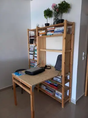 a wooden desk with a book shelf with books at Appart à Ola Blanca 2 près de Sidi Rahal in Bir Jedíd Saint-Hubert