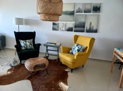 a living room with two chairs and a table at Appart à Ola Blanca 2 près de Sidi Rahal in Bir Jedíd Saint-Hubert