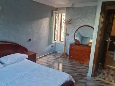 a bedroom with a bed and a dresser and a mirror at Belle maison à Harhoura proche de la plage in Rabat