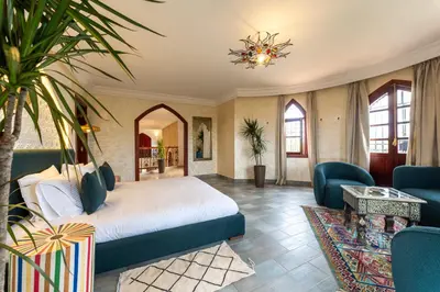a bedroom with a bed and a living room at Château Loriana in Bouznika