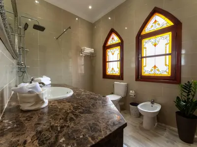 a bathroom with a sink and a toilet and a window at Château Loriana in Bouznika