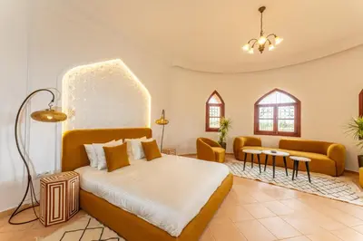 a bedroom with a bed and a living room at Château Loriana in Bouznika