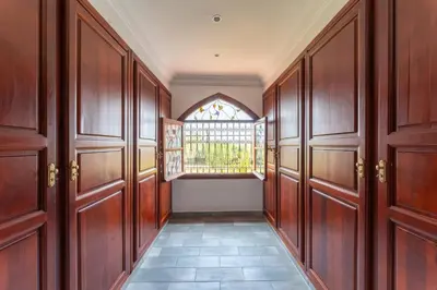 a hallway with wooden doors and a window at Château Loriana in Bouznika