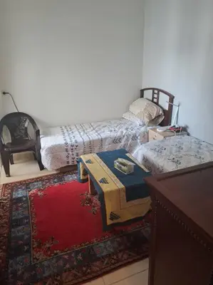 a room with a bed and a table and a rug at Moonskhirat in Skhirat