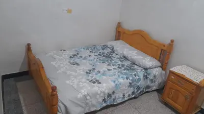 a bedroom with a bed with a blue and white comforter at Msn in Rabat