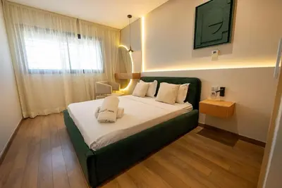 a bedroom with a large bed with a green headboard at Sophisticated 3BR with Ample Space & Top Amenities in Rabat