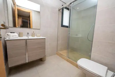 a bathroom with a shower and a sink and a toilet at Prestigia Gem Spacious 3BR Flat in Hay Riad in Rabat